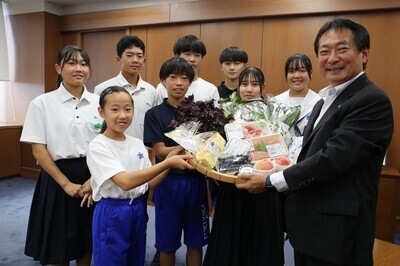 野菜や肉などの地場食品を受け取る様子